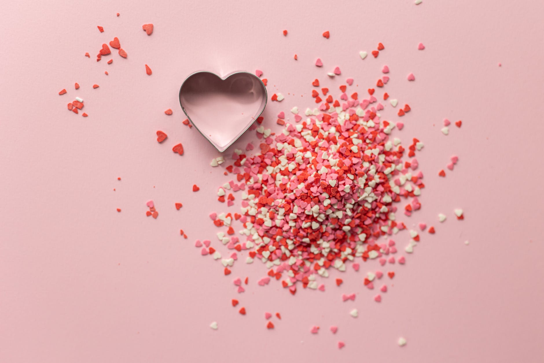 confetti near heart shaped baking tin on surface for valentine day